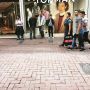 Mannen wachten buiten op vrouwen die winkelen in de topman.